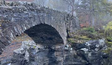 Historic stone bridge over a rocky landscape.