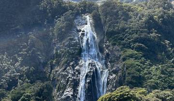 Tall waterfall cascading down a lush green cliff.