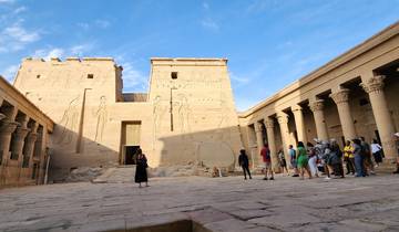 Tourists exploring ancient Egyptian temples with hieroglyphs.