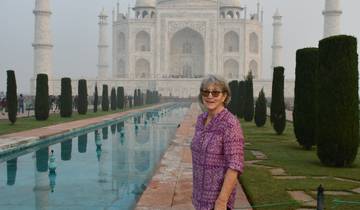 Woman standing in front of the Taj Mahal with reflecting pool.