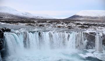 Stunning frozen waterfall surrounded by a snowy landscape.