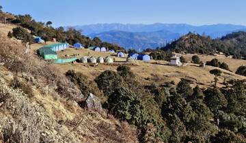 Tent campsite in a mountainous region under a blue sky.