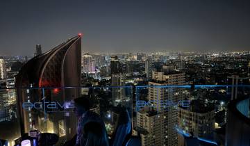 Cityscape view from a rooftop bar at night.
