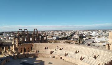 View of an ancient amphitheater with city in the background.