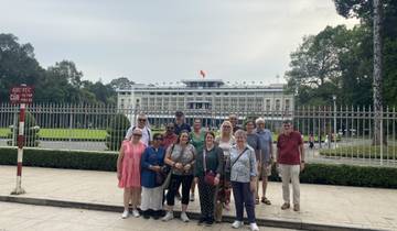 Group photo in front of a large building with a flag and grounds.