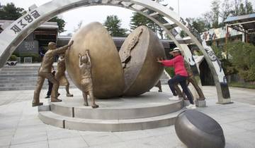 Tourist posing with sculptures of a divided sphere.