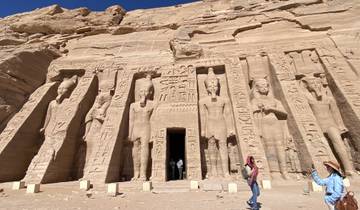 Tourists exploring Abu Simbel with carved statues.