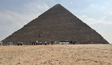 Large pyramid with tourists gathered at the base.