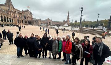 Group of people posing at Plaza de España with its iconic architecture.