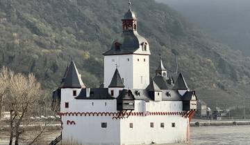 Castle along a river with hills in the background