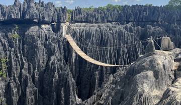 A rope bridge over rugged limestone formations.