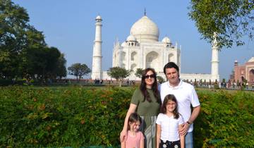 Family posing in front of the Taj Mahal.