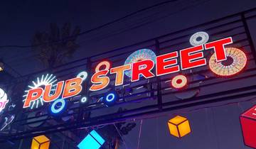 Vibrant sign for Pub Street at night with decorations.
