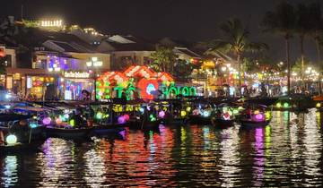 Boats with illuminated lanterns on a river at night.