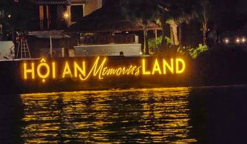 Illuminated sign saying 'Hội An Memories Land' at night.