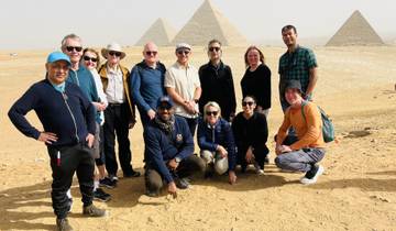Group of tourists posing in front of pyramids.
