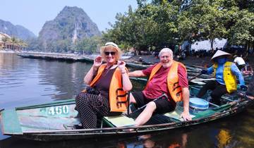 Couple enjoying a boat ride with scenic background.