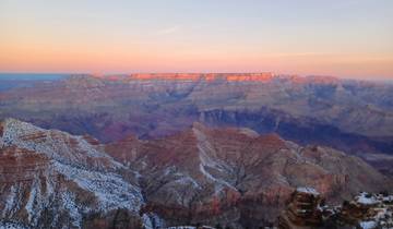 The Grand Canyon at sunset with layers of colors on the rocky landscape.
