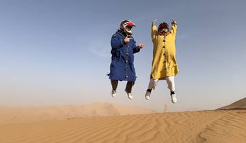 Two people jumping with joy in the desert.