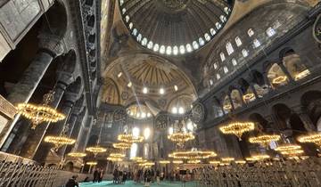 Interior view of a large historical mosque with chandeliers