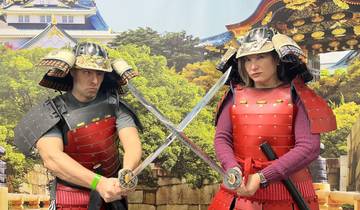 Two people wearing samurai armor posing with swords.