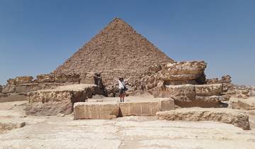 Person standing in front of an ancient pyramid.