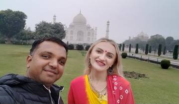 Two people smiling in front of the Taj Mahal.