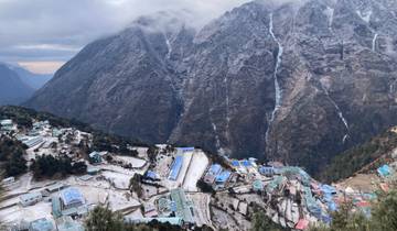 Mountain village with dramatic snowy cliffs in the background.