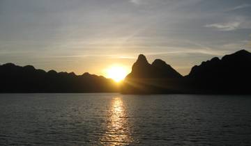 Sunset over ocean with mountains.