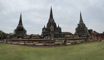 Three ancient stupas against a cloudy sky.