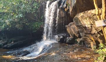 Waterfall cascading over rocks surrounded by greenery.