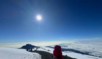 Group hiking on a snowy mountain with clear skies