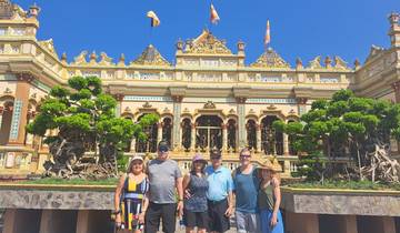 Tourists posing in front of a decorative temple.