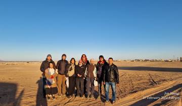 Group of people posing in a desert.
