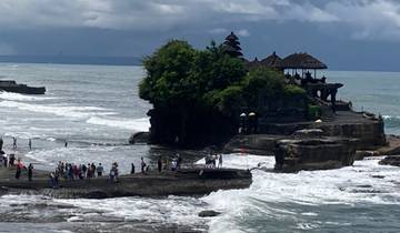 Temple on a rocky coastline with crashing waves.