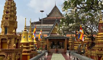 Ornate temple in Phnom Penh with decorative elements and flags.
