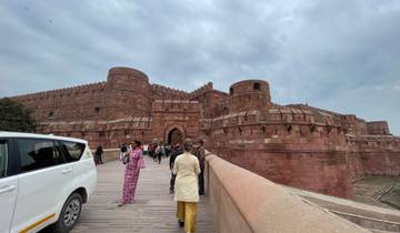 People entering a large, historic fort structure.