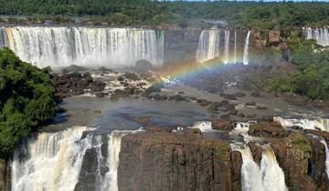 Wide view of Iguazu Falls with a rainbow.