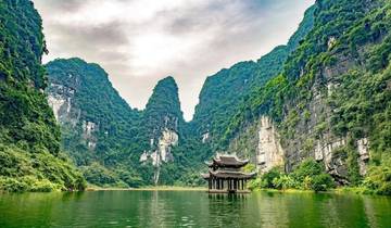 Pagoda surrounded by limestone karsts on water.