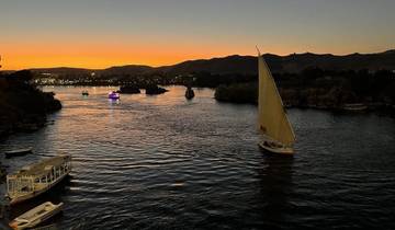 Sailboats on a river during sunset.