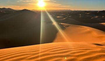 Sunset over sand dunes in the desert.