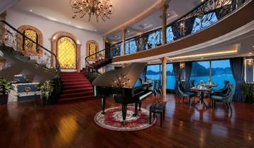 Elegant dining and lounge area on a cruise ship with a piano.