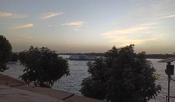River scene with a cruise ship and trees.