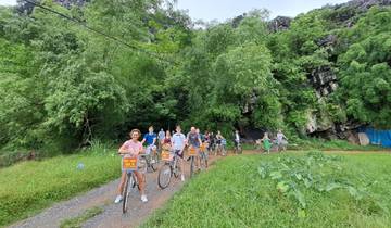 Cyclists stopped on a path in lush greenery.