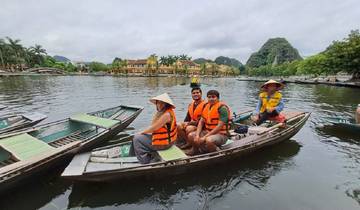 Family on a boat in traditional hats on a lake.