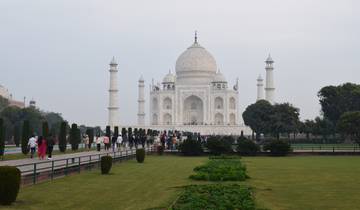 The Taj Mahal in Agra with a group of people walking in the foreground.