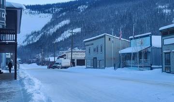 Snow-covered town street with classic wooden buildings.