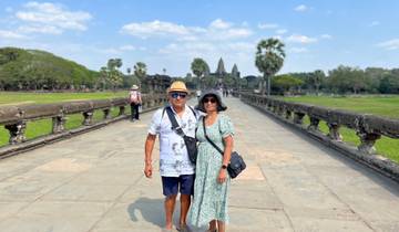 Couple posing on a stone pathway with Angkor Wat in the background.
