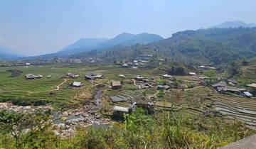 Terraced rice fields in a valley surrounded by hills.