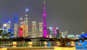 Shanghai skyline lit up at night, with the Oriental Pearl Tower prominently visible.